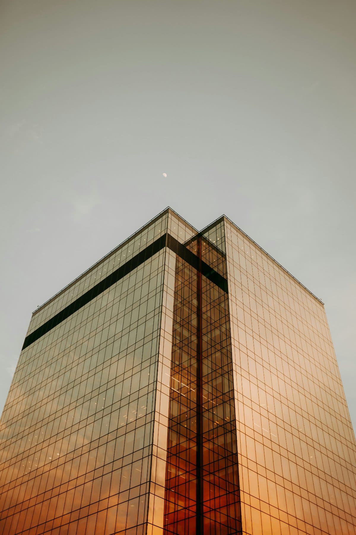 Edificio moderno de vidrio en contrapicado al atardecer
